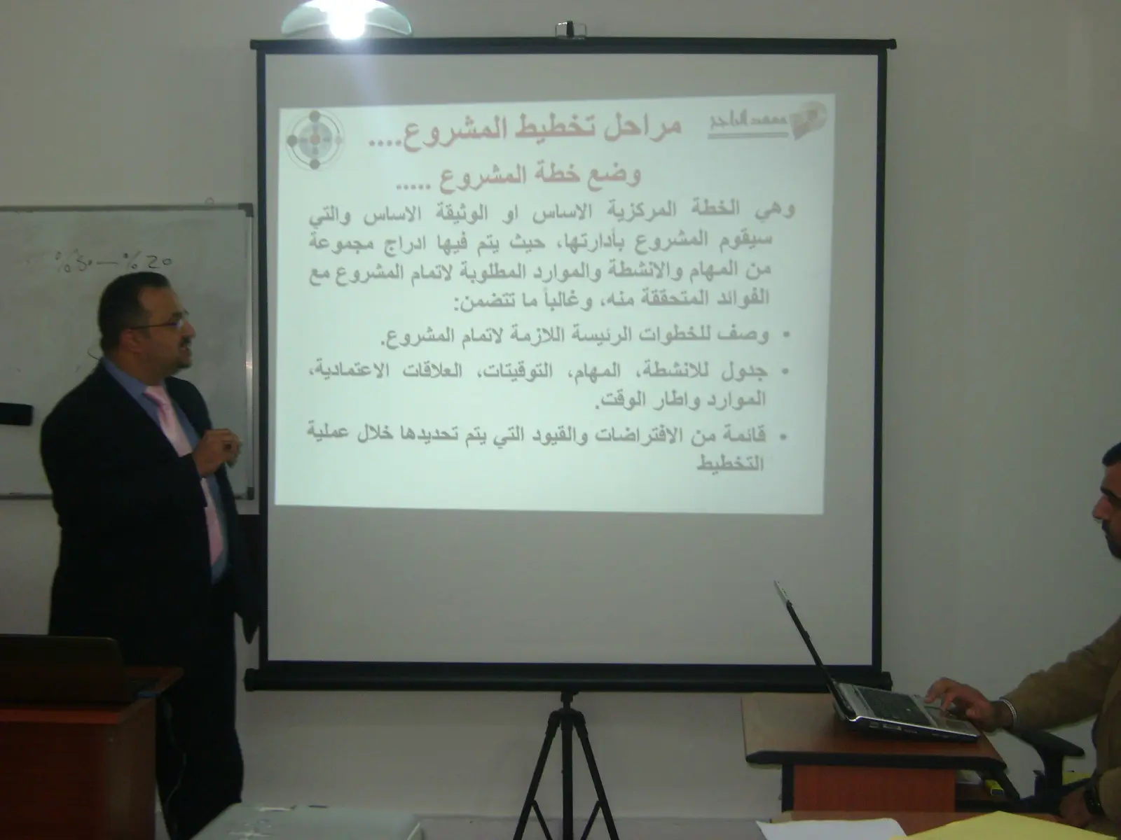 محاضر يشرح مراحل تخطيط المشروع على شاشة العرض
